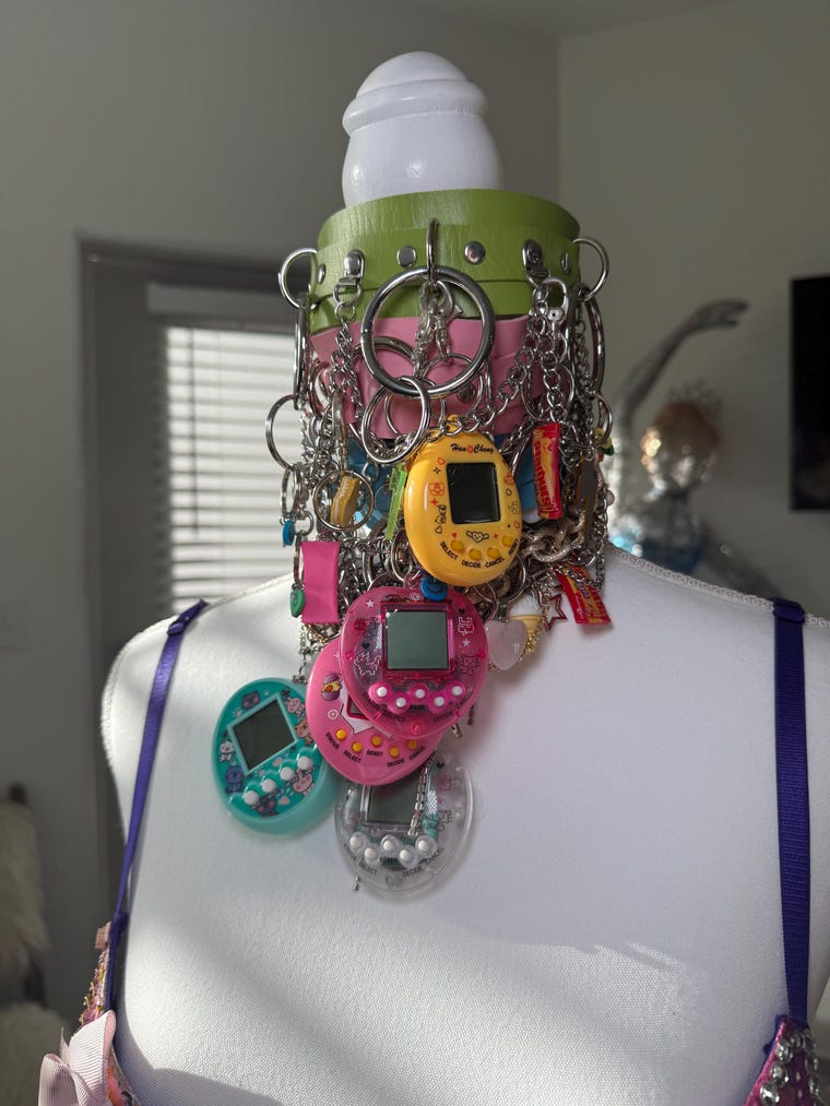 Handmade Y2K charm choker with virtual pet keychains on a display bust